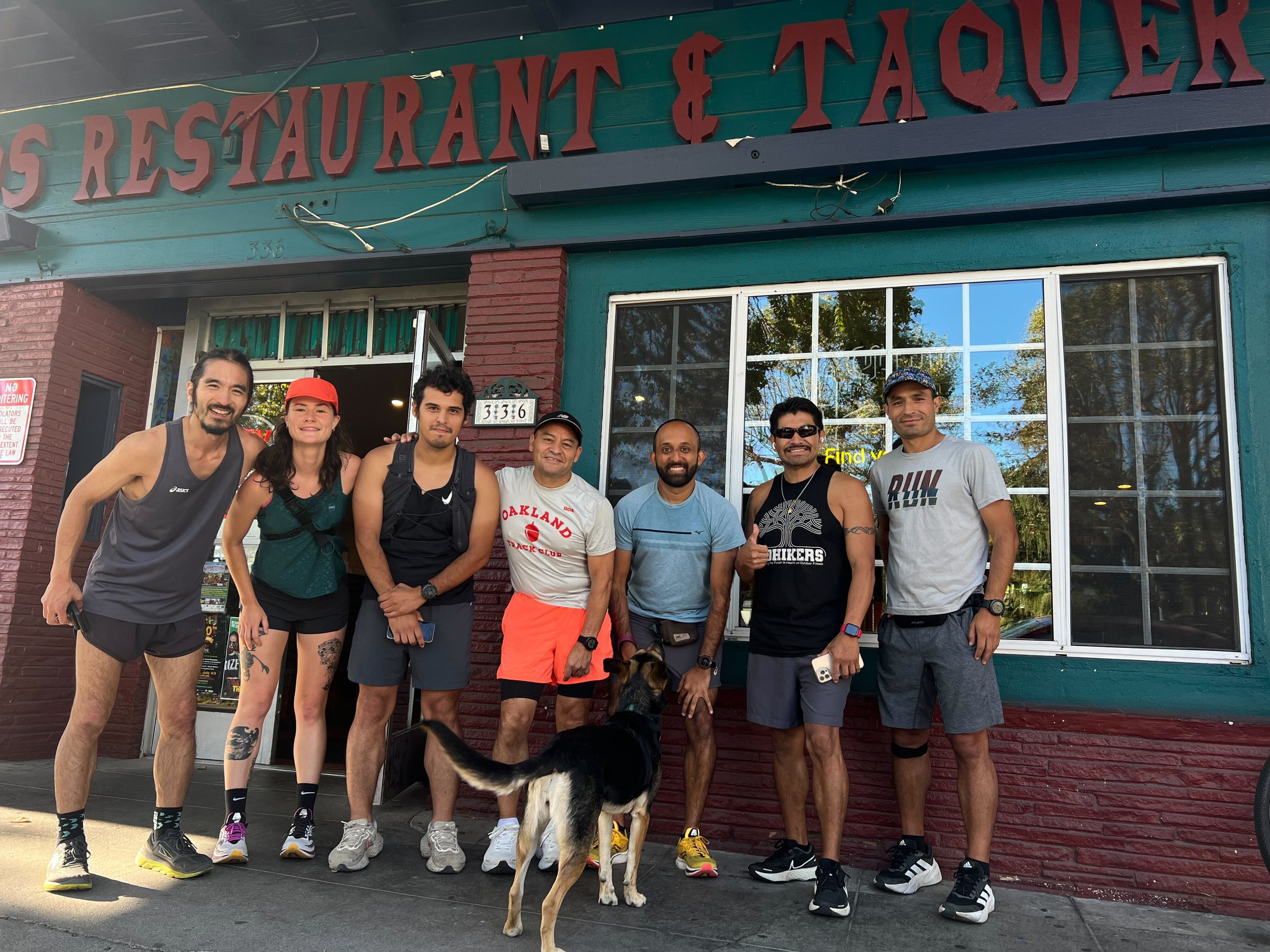 Oakland Track Club members gathered in front of a restaurant